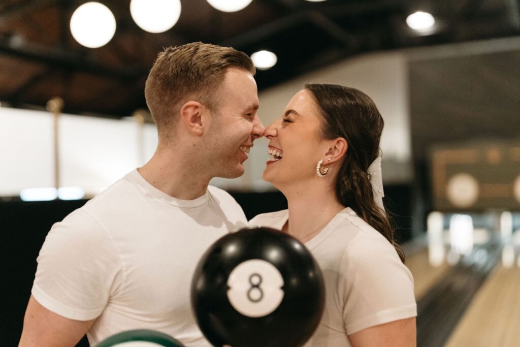 couple laughing while holding bowling balls