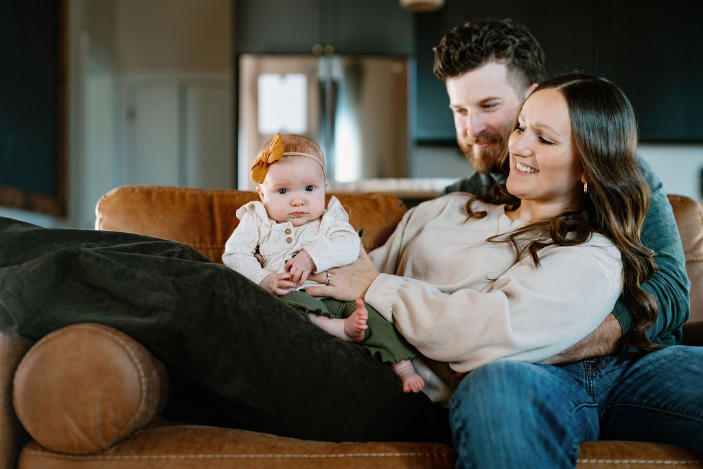 family sitting on a couch with baby